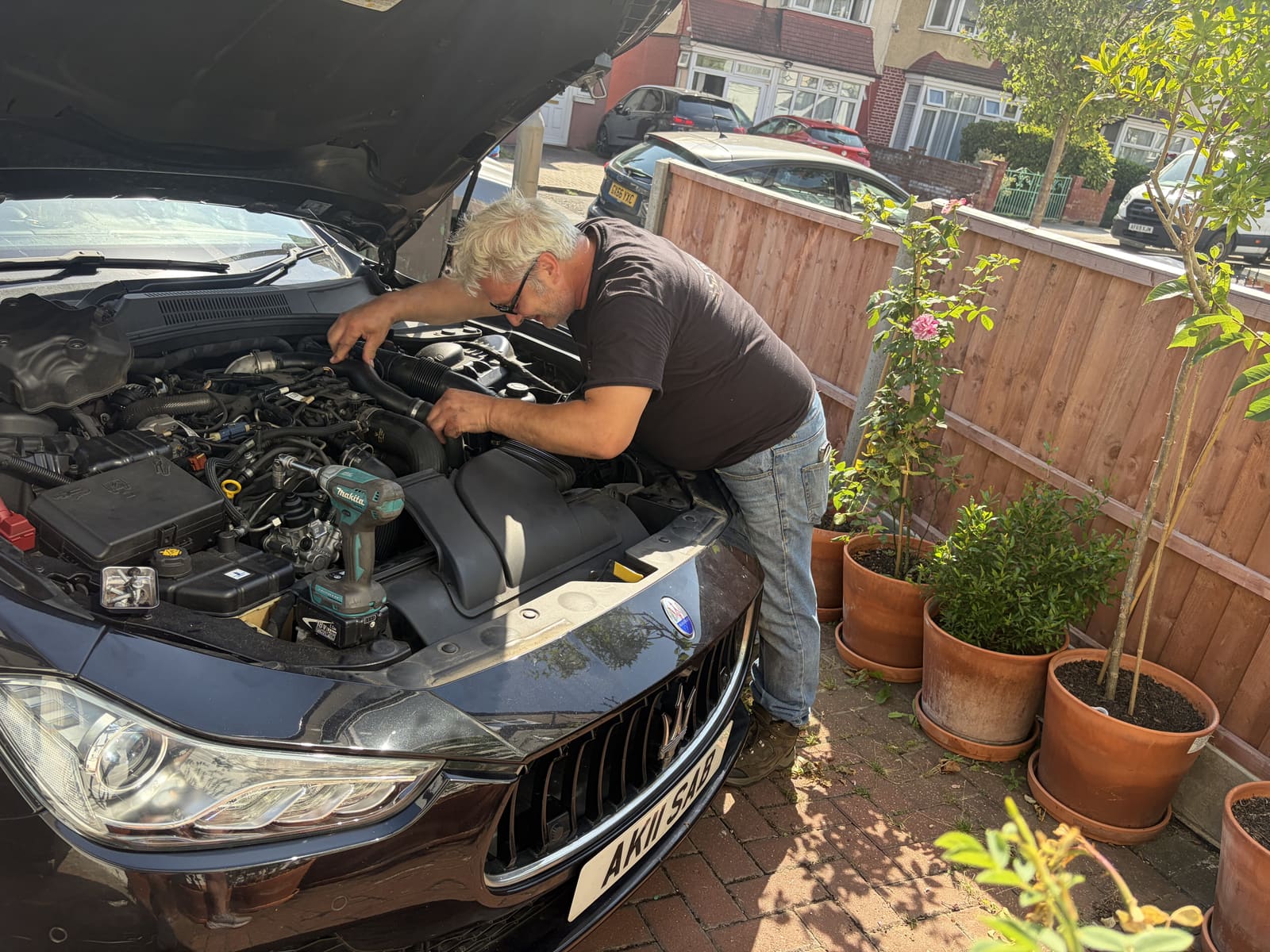 SL Works technician servicing a Maserati engine bay