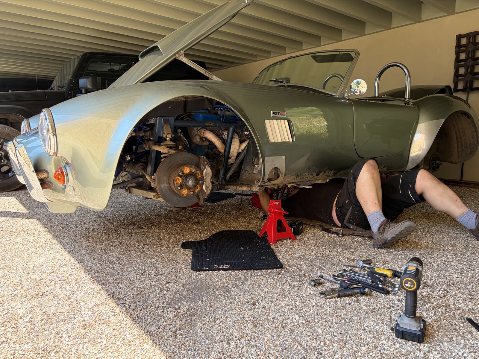Shelby Cobra 427 raised with technician underneath