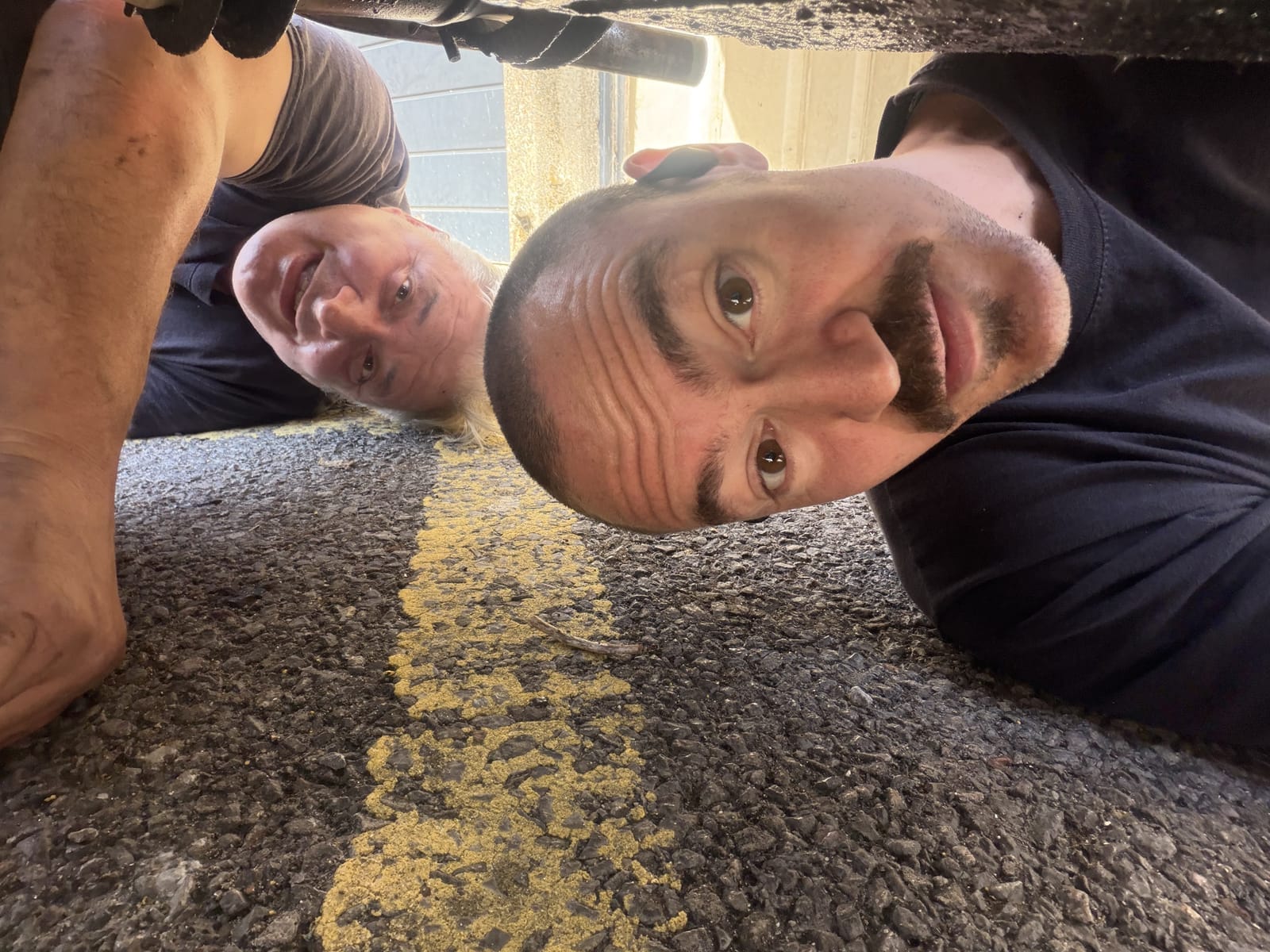 Michele and Francisco working underneath a car at SL Works Ltd